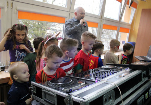 Dzieci oglądają konsoletę DJ-a.