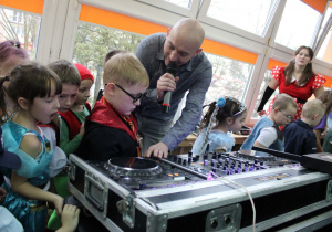 Pan Krzysztof pokazuje przedszkolakom, jak miksuje muzykę.