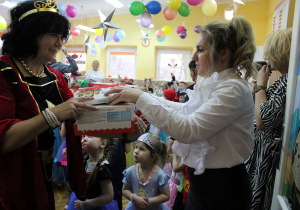 Pani Dyrektor wręcza Pani Reni z grupy Słoneczek słodki upominek dla dzieci.
