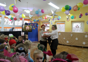 Krasnoludki czekają na słodkości, które przyjmuje Pani Agnieszka od Pani Dyrektor.