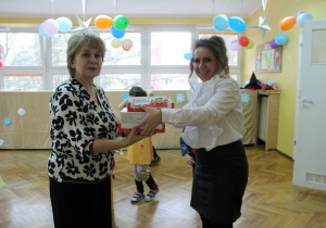 Pani Dyrektor z radością przekazuje słodki upominek dla grupy Misiaczków na ręce Pani Reni.