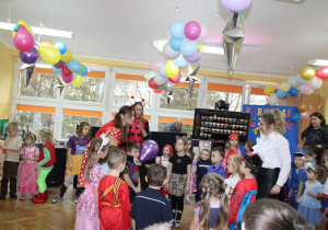 Pani Karolina tłumaczy dzieciom zasady konkursu z balonem.