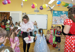 Pani Dyrektor wręcza Adzie nagrodę za zwycięstwo w zabawie z balonem.