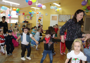 Pani Ewelinka tanecznym krokiem prowadzi dzieci swojej grupy.