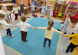 Dzieci bawią się na dywanie w zabawę "Mój pączusiu"