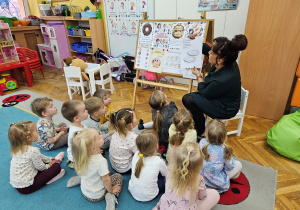 Pani Kamilka pokazuje dzieciom ilustracje do wierszyka o pączku