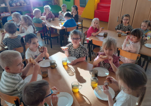 Z okazji Tłustego Czwartku dzieci jedzą na podwieczorek pyszne racuchy.