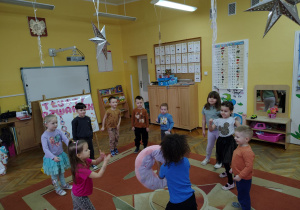 Dzieci podczas zabawy ruchowej przy piosence o pączkach z maskotką donatem.