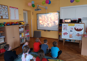 Oglądając film edukacyjny przedszkolaki dowiedziały się, że dawniej w Tłusty Czwartek jedzono tłuste potrawy.