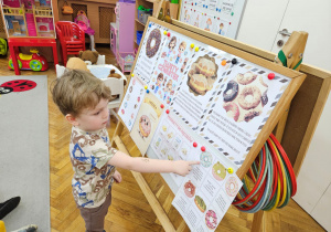 Adaś wskazuje na tablicy właściwego pączka