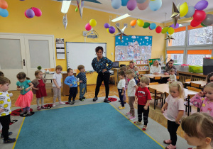 Dzieci wraz z panią Kamilką kręcą biodrami w zabawie muzyczno-ruchowej