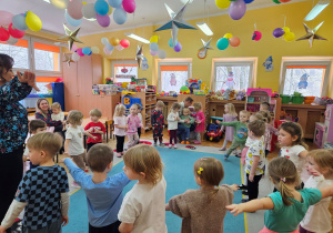 Dzieci naśladują pingwinka w zabawie muzyczno-ruchowej