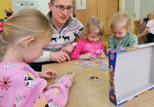 Nasi goście-Wojtuś wraz z tatą oraz Milenką i Agatką układają puzzle przy stoliku