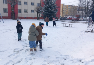 Krasnoludki bawią się śniegiem.