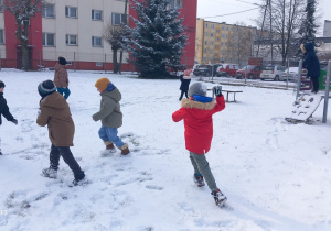Przedszkolaki rzucają się śnieżkami.