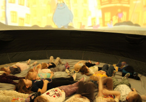 Dzieci w skupieniu przyglądają się kolorowym obrazom