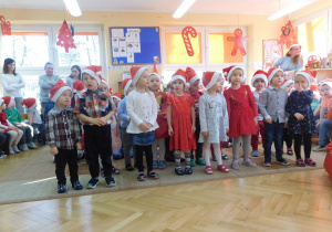 Grupa maluszków spiewa dla Mikołaja piosenkę.