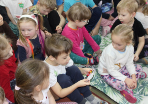 Przedszkolaki oglądają naszywkę przedstawiającą orła bielika.