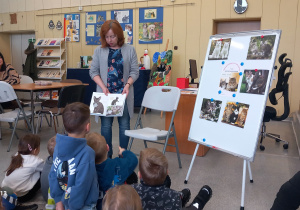 Prowadząca pokazuje dzieciom różne rasy kotów.