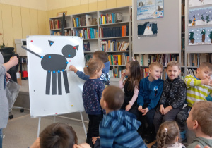 Dzieci układają sylwetę kota na tablicy.