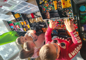 Chłopcy wybierają klocki z pojemników.