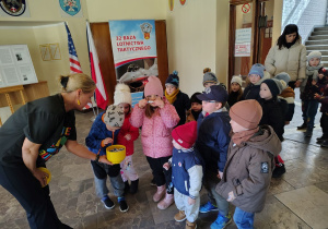 Przedszkolaki częstują się cukierkami.