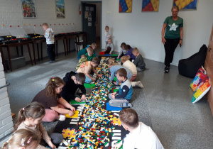 Przedszkolaki konstruują i wybierają klocki w gablotach.