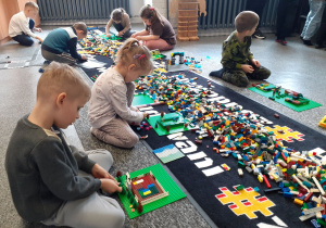 Staś z koleżankami wybierają potrzebne klocki.