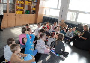 Pani bibliotekarka czyta dzieciom książkę: „Jestem najsilniejszy”.