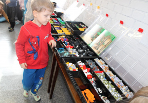 Antoś ogląda klocki w pojemnikach.