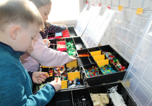 Julian i Lilia wybierają spośród klocków Lego elementy specjalne i akcesoria.