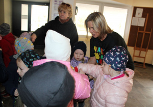 Pani Magda na pożegnanie częstuje dzieci cukierkami.