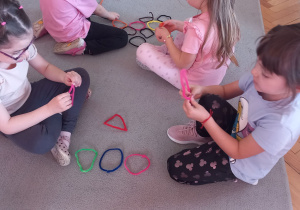 Przedszkolaki formują z drucików figury geometryczne.