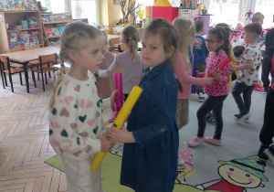 Kaja i Hania tańczą w kole trzymając się za Bum bum rurki.