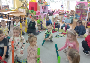 Dzieci uderzają rurkami o podłogę i przeliczają .