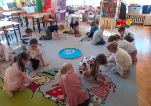 Dzieci - „gołębie” przeliczają ziarna fasoli zebrane do „gniazd” – obręczy.