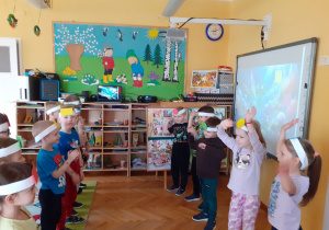 Pięcioro Krasnoludków z kołem na opasce tańczy przed grupą.