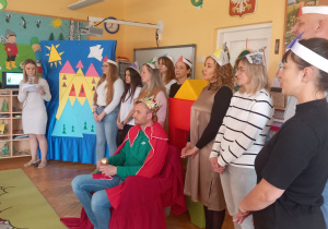 Aktorzy stoją przed publicznością.