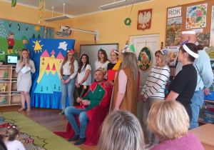 Król siedzi na tronie a dworzanie wręczają mu tacę.