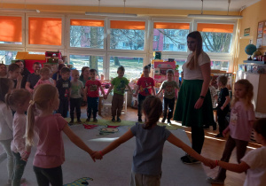 Dzieci stoją w kole a ani Karolina w środku.