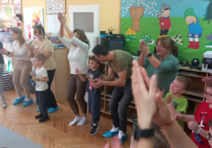 Rodzice i dzieci klaszczą w ręce.