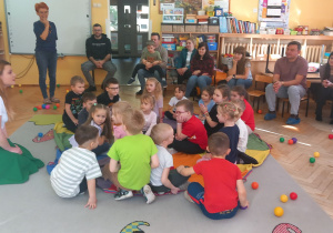 Przedszkolaki siedzą na chuście a pani Karolina tłumaczy kolejne ćwiczenie.