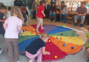 Przedszkolaki zbierają piłeczki.