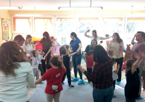 Rodzice tańczą z dziećmi w kółeczkach.