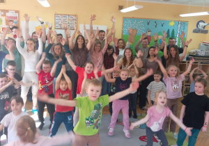 Wszyscy uczestnicy warsztatów trzymają ręce w górze.