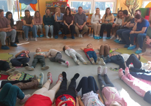 Krasnoludki relaksują się na dywanie leżąc na plecach.