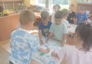 Chłopcy rysują koła mazakami.