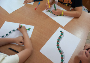 Przedszkolaki kolorują gąsienicę według podanego kodu.