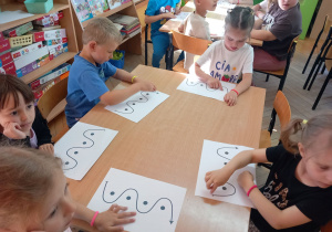 Dzieci wodzą rękami po muzografie do piosenki „Rzeka”