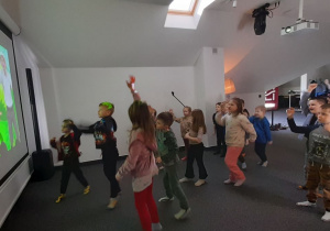 Przedszkolaki w zabawie ruchowej naśladują skaczące małpki.